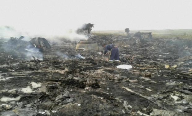 In this image taken from video, people walk on the debris at the crash site after a passenger plan was shot down as it flew over Ukraine, near the village of Hrabove, in eastern Ukraine (Photo: AP) In this image taken from video, people walk on the debris at the crash site after a passenger plan was shot down as it flew over Ukraine, near the village of Hrabove, in eastern Ukraine (Photo: AP)